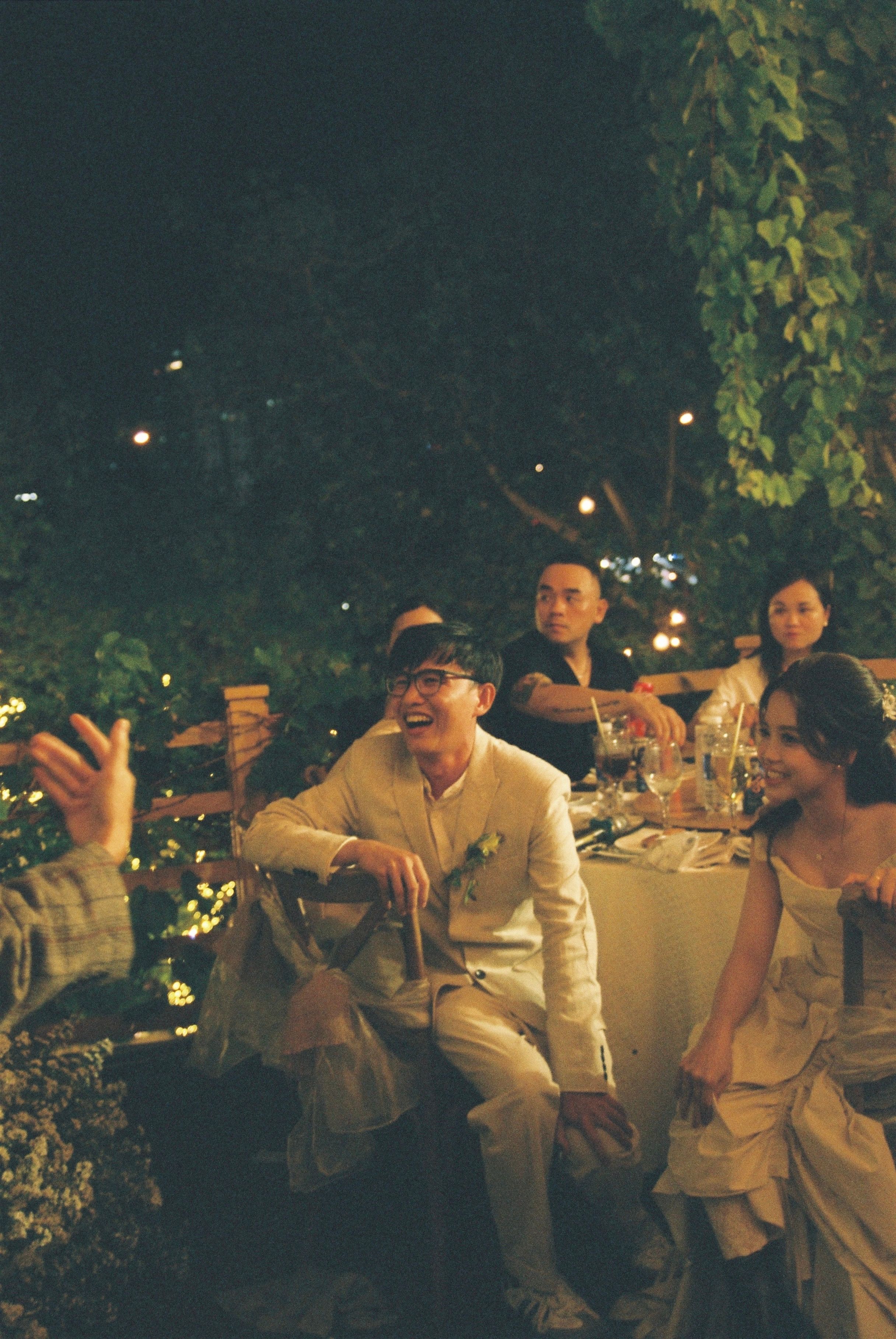 Guests enjoying an evening wedding celebration outdoors